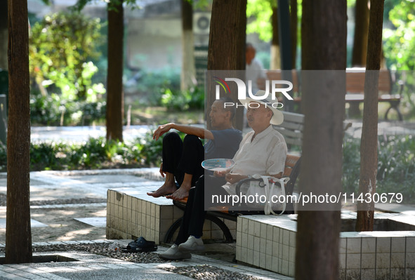 Senior citizens are relaxing at a park in Fuyang, China, on July 22, 2024. 