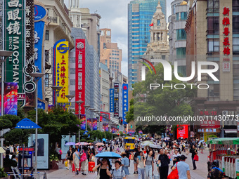 Tourists are traveling along the Nanjing Road pedestrian street in Shanghai, China, on July 24, 2024. (