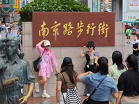 Tourists are traveling along the Nanjing Road pedestrian street in Shanghai, China, on July 24, 2024. (