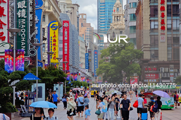 Tourists are traveling along the Nanjing Road pedestrian street in Shanghai, China, on July 24, 2024. 