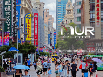 Tourists are traveling along the Nanjing Road pedestrian street in Shanghai, China, on July 24, 2024. (