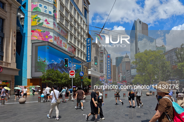 Tourists are traveling along the Nanjing Road pedestrian street in Shanghai, China, on July 24, 2024. 