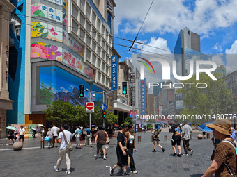 Tourists are traveling along the Nanjing Road pedestrian street in Shanghai, China, on July 24, 2024. (