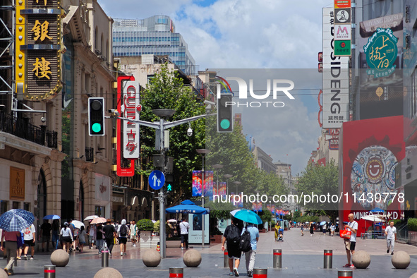 Tourists are traveling along the Nanjing Road pedestrian street in Shanghai, China, on July 24, 2024. 