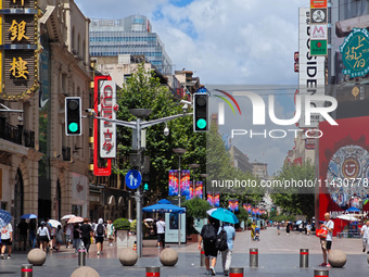 Tourists are traveling along the Nanjing Road pedestrian street in Shanghai, China, on July 24, 2024. (