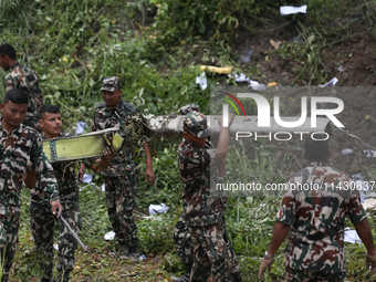 Rescuers from Nepal's security agencies are salvaging the remains of a passenger aircraft of Saurya Airlines that crashed at Tribhuvan Inter...