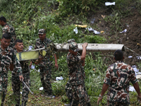 Rescuers from Nepal's security agencies are salvaging the remains of a passenger aircraft of Saurya Airlines that crashed at Tribhuvan Inter...