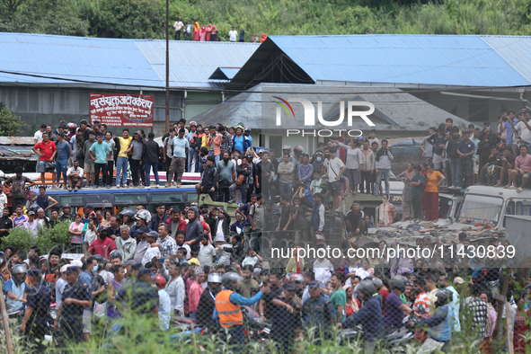 Locals are gathering outside the Tribhuvan International Airport after a passenger aircraft is crashing in Kathmandu, Nepal, on July 24, 202...