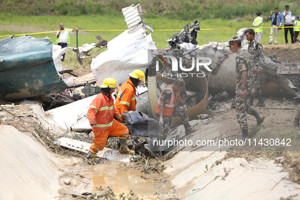 Rescuers from Nepal's security agencies are salvaging the remains of a passenger aircraft of Saurya Airlines that crashed at Tribhuvan Inter...