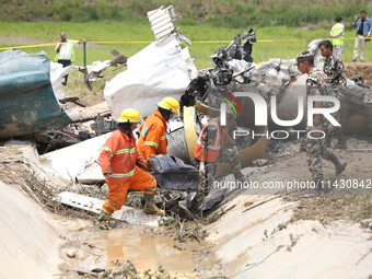 Rescuers from Nepal's security agencies are salvaging the remains of a passenger aircraft of Saurya Airlines that crashed at Tribhuvan Inter...