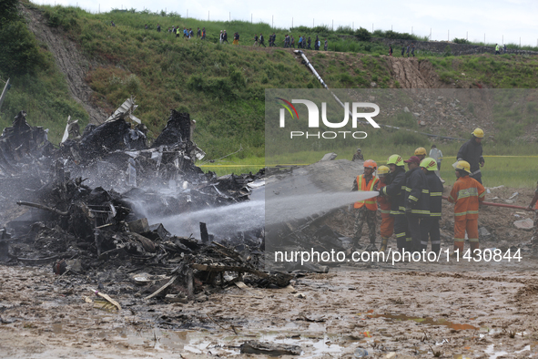 Rescuers from Nepal's security agencies are salvaging the remains of a passenger aircraft of Saurya Airlines that crashed at Tribhuvan Inter...