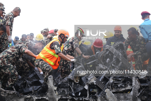 Rescuers from Nepal's security agencies are salvaging the remains of a passenger aircraft of Saurya Airlines that crashed at Tribhuvan Inter...