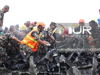 Rescuers from Nepal's security agencies are salvaging the remains of a passenger aircraft of Saurya Airlines that crashed at Tribhuvan Inter...