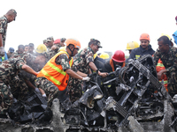 Rescuers from Nepal's security agencies are salvaging the remains of a passenger aircraft of Saurya Airlines that crashed at Tribhuvan Inter...