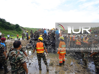 Rescuers from Nepal's security agencies are salvaging the remains of a passenger aircraft of Saurya Airlines that crashed at Tribhuvan Inter...