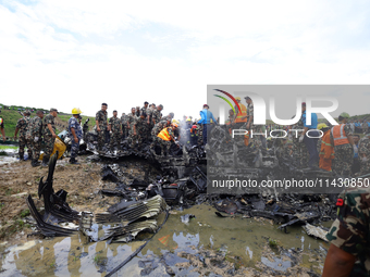 Rescuers from Nepal's security agencies are salvaging the remains of a passenger aircraft of Saurya Airlines that crashed at Tribhuvan Inter...