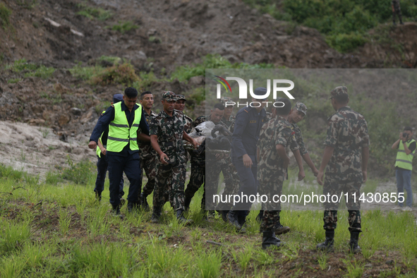 Rescuers from Nepal's security agencies are carrying charred bodies of a dead passenger retrieved from a passenger aircraft of Saurya Airlin...