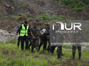 Rescuers from Nepal's security agencies are carrying charred bodies of a dead passenger retrieved from a passenger aircraft of Saurya Airlin...