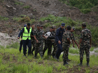 Rescuers from Nepal's security agencies are carrying charred bodies of a dead passenger retrieved from a passenger aircraft of Saurya Airlin...