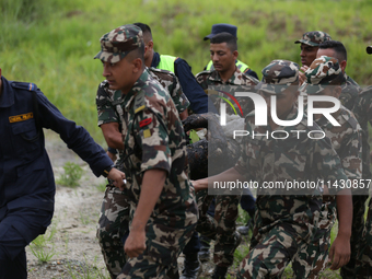 Rescuers from Nepal's security agencies are carrying charred bodies of a dead passenger retrieved from a passenger aircraft of Saurya Airlin...