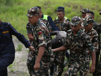 Rescuers from Nepal's security agencies are carrying charred bodies of a dead passenger retrieved from a passenger aircraft of Saurya Airlin...