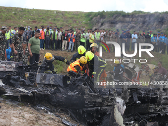 Rescuers from Nepal's security agencies are salvaging the remains of a passenger aircraft of Saurya Airlines that crashed at Tribhuvan Inter...