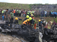 Rescuers from Nepal's security agencies are salvaging the remains of a passenger aircraft of Saurya Airlines that crashed at Tribhuvan Inter...