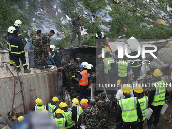 Rescuers from Nepal's security agencies are salvaging the remains of a passenger aircraft of Saurya Airlines that crashed at Tribhuvan Inter...