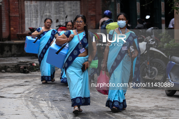 Health workers are walking during a polio vaccination campaign in Patan, Lalitpur, on July 24, 2024. The Nepal government is starting a four...