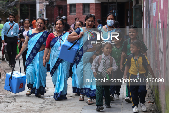 Health workers are walking during a polio vaccination campaign in Patan, Lalitpur, on July 24, 2024. The Nepal government is starting a four...