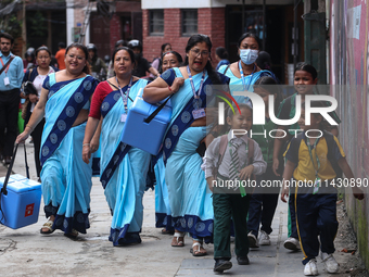 Health workers are walking during a polio vaccination campaign in Patan, Lalitpur, on July 24, 2024. The Nepal government is starting a four...