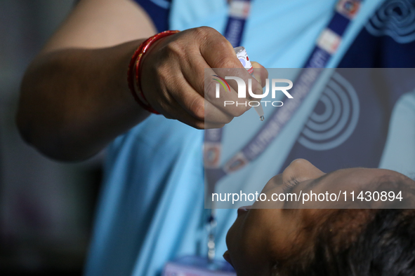 A health worker is administering a polio vaccine drop to a child in Patan, Lalitpur, on July 24, 2024. The Nepal government is starting a fo...