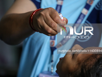 A health worker is administering a polio vaccine drop to a child in Patan, Lalitpur, on July 24, 2024. The Nepal government is starting a fo...