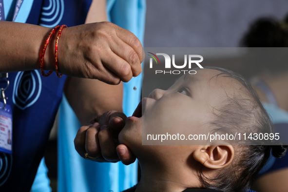 A health worker is administering a polio vaccine drop to a child in Patan, Lalitpur, on July 24, 2024. The Nepal government is starting a fo...