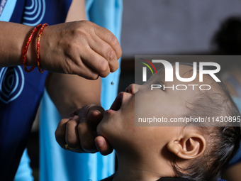 A health worker is administering a polio vaccine drop to a child in Patan, Lalitpur, on July 24, 2024. The Nepal government is starting a fo...