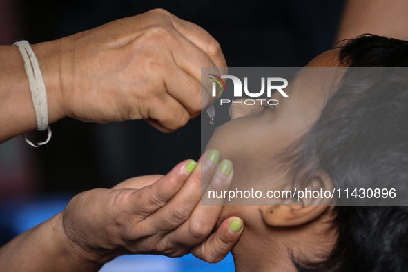 A health worker is administering a polio vaccine drop to a child in Patan, Lalitpur, on July 24, 2024. The Nepal government is starting a fo...