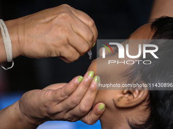 A health worker is administering a polio vaccine drop to a child in Patan, Lalitpur, on July 24, 2024. The Nepal government is starting a fo...