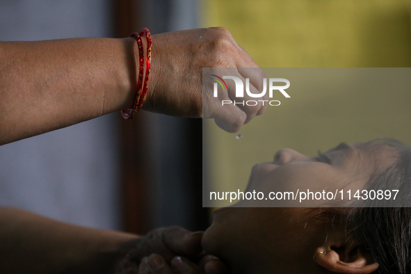 A health worker is administering a polio vaccine drop to a child in Patan, Lalitpur, on July 24, 2024. The Nepal government is starting a fo...