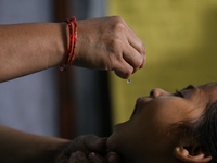 A health worker is administering a polio vaccine drop to a child in Patan, Lalitpur, on July 24, 2024. The Nepal government is starting a fo...