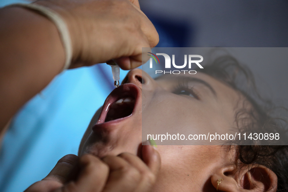 A health worker is administering a polio vaccine drop to a child in Patan, Lalitpur, on July 24, 2024. The Nepal government is starting a fo...