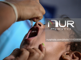 A health worker is administering a polio vaccine drop to a child in Patan, Lalitpur, on July 24, 2024. The Nepal government is starting a fo...