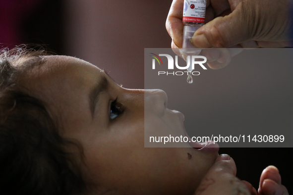 A health worker is administering a polio vaccine drop to a child in Patan, Lalitpur, on July 24, 2024. The Nepal government is starting a fo...