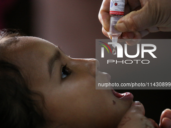 A health worker is administering a polio vaccine drop to a child in Patan, Lalitpur, on July 24, 2024. The Nepal government is starting a fo...