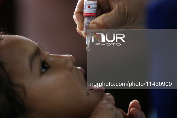 A health worker is administering a polio vaccine drop to a child in Patan, Lalitpur, on July 24, 2024. The Nepal government is starting a fo...