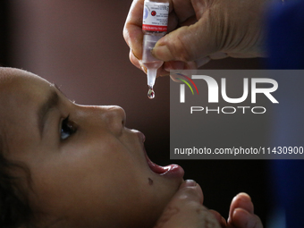 A health worker is administering a polio vaccine drop to a child in Patan, Lalitpur, on July 24, 2024. The Nepal government is starting a fo...