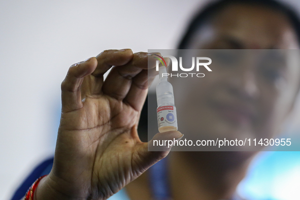 A Nepali health worker is holding a vial of 'OPV' as she poses for a photo during a door-to-door immunization campaign following the governm...