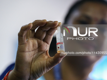 A Nepali health worker is holding a vial of 'OPV' as she poses for a photo during a door-to-door immunization campaign following the governm...