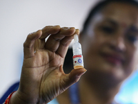 A Nepali health worker is holding a vial of 'OPV' as she poses for a photo during a door-to-door immunization campaign following the governm...