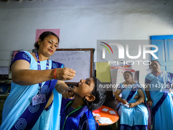 A Nepali health worker is administering 'OPV' to a child during a door-to-door immunization campaign following the government's special immu...