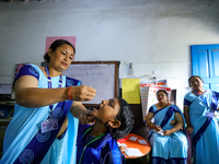 A Nepali health worker is administering 'OPV' to a child during a door-to-door immunization campaign following the government's special immu...